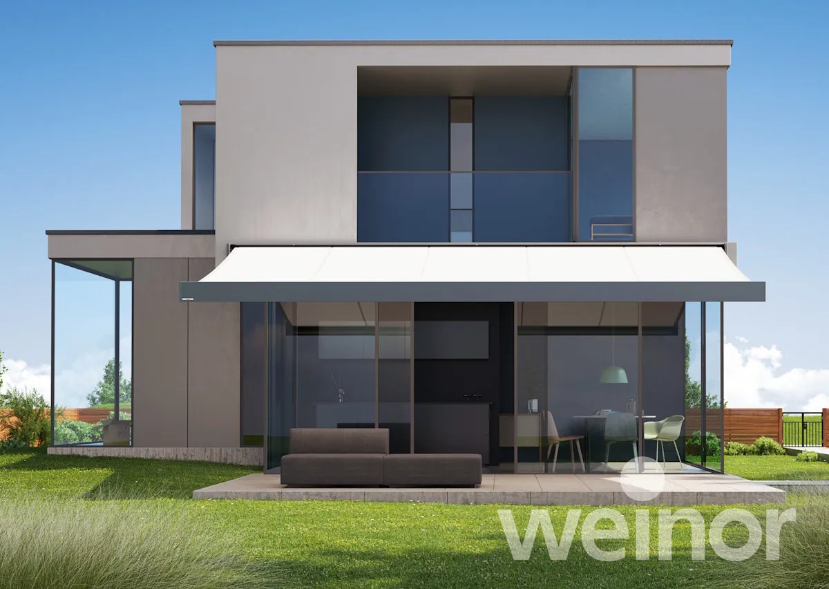 Modernes Haus mit großer Terrasse und weißer Markise als Sonnenschutz