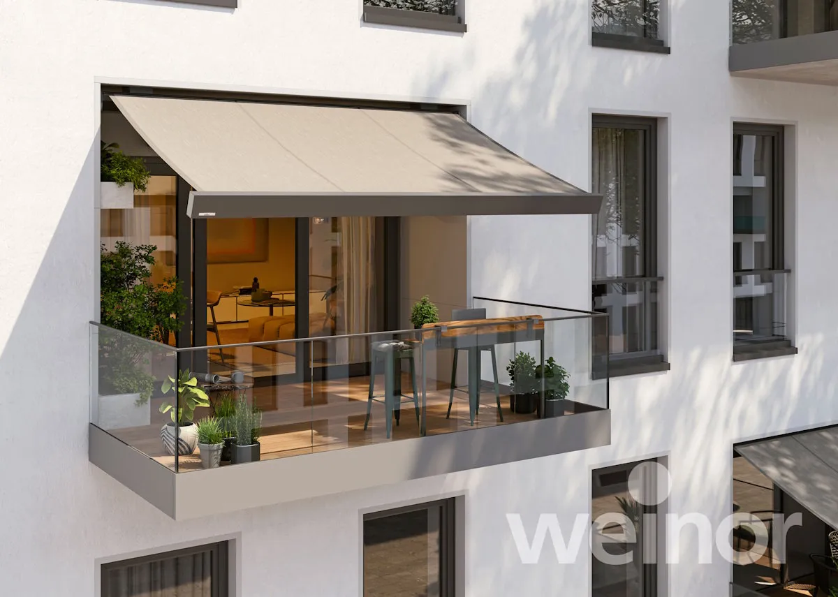Balkon mit Markise als Sonnenschutz, Glasgeländer und Sitzgruppe am Haus